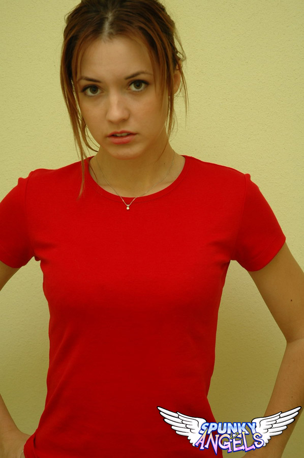 Девушка с красивой талией трясет аппетитными ягодицами и и несмело задирает красную футболку и показывает плоский живот